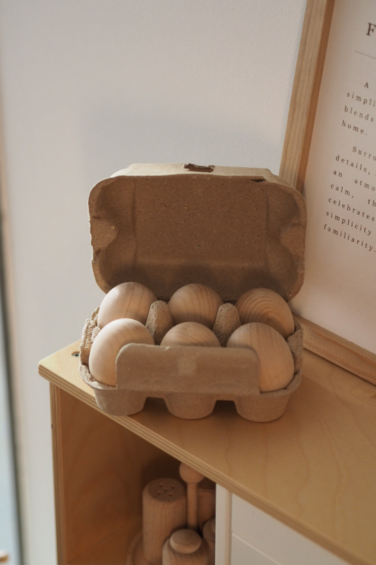 Carton of wooden play eggs on a wooden play kitchen